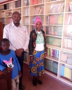 A family standing in front of some books