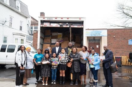 A group of people standing in front of a truck.