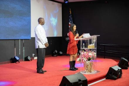 A woman is giving a speech at the podium