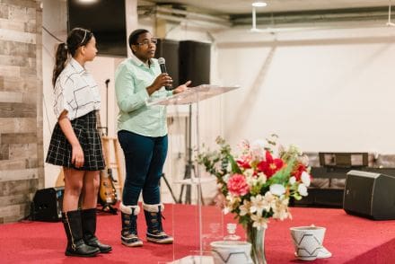 Two women standing in front of a microphone.