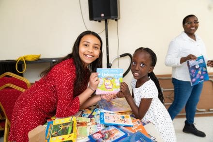 Two girls sitting at a table with books