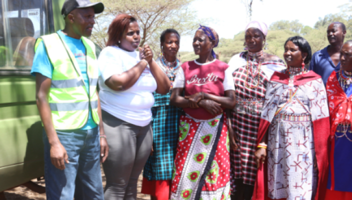 A group of people standing together in front of trees.