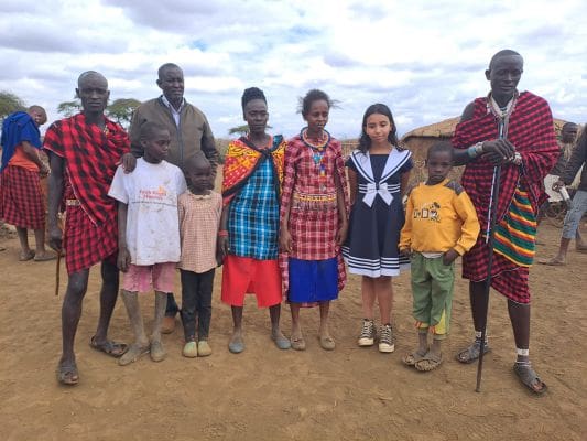 A group of people standing in the dirt.